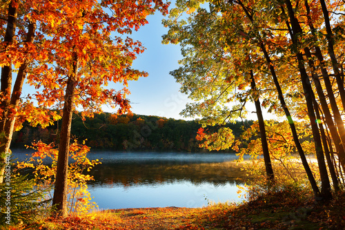 Fototapeta Naklejka Na Ścianę i Meble -  Beautiful Sunrise over a lake with fall foliage in foreground, Boston Massachusetts.