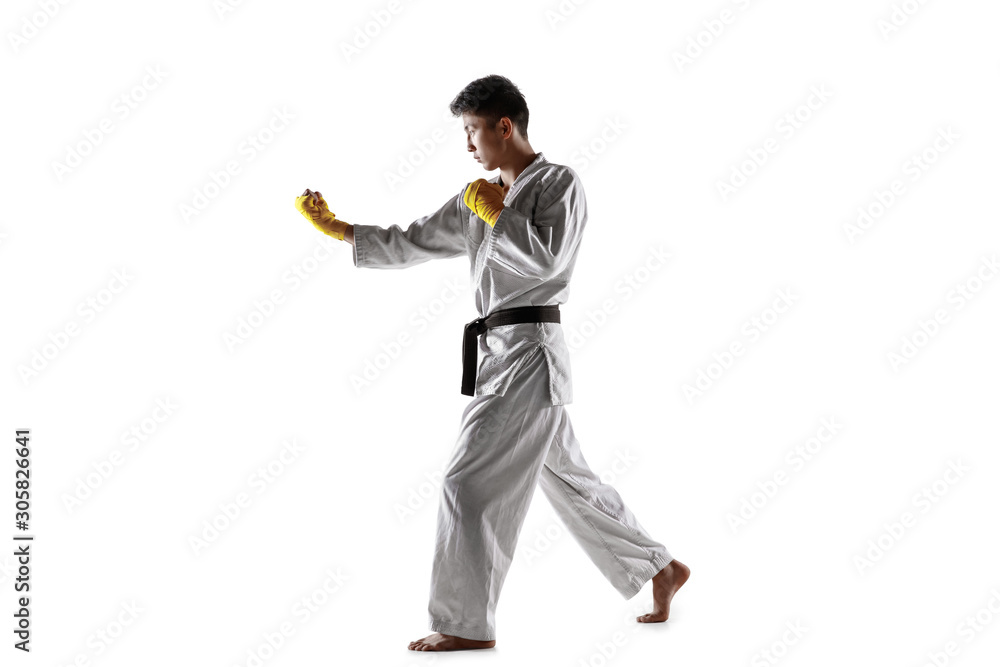 Confident korean man in kimono practicing hand-to-hand combat, martial arts. Young male fighter with black belt training isolated on white studio background. Concept of healthy lifestyle, sport. Confident korean man in kimono practicing hand-to-hand combat, martial arts. Young male fighter with black belt training isolated on white studio background. Concept of healthy lifestyle, sport.