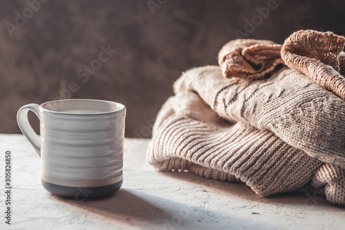 Cups of coffee with knitted warm pastel color sweaters