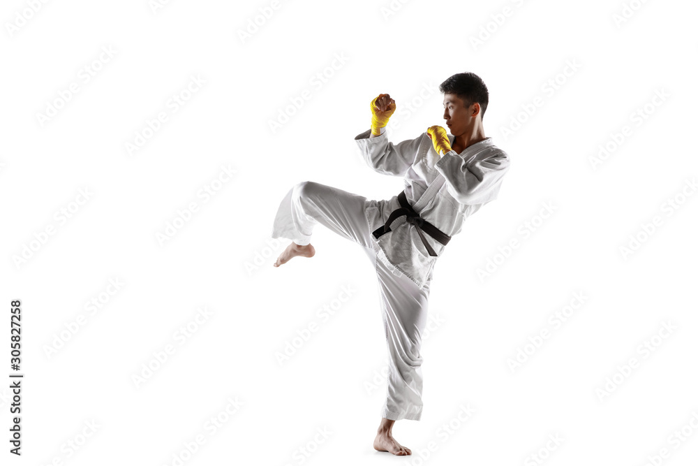 Confident korean man in kimono practicing hand-to-hand combat, martial arts. Young male fighter with black belt training isolated on white studio background. Concept of healthy lifestyle, sport. Confident korean man in kimono practicing hand-to-hand combat, martial arts. Young male fighter with black belt training isolated on white studio background. Concept of healthy lifestyle, sport.