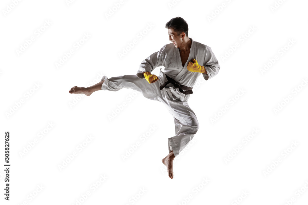 Confident korean man in kimono practicing hand-to-hand combat, martial arts. Young male fighter with black belt training isolated on white studio background. Concept of healthy lifestyle, sport. Confident korean man in kimono practicing hand-to-hand combat, martial arts. Young male fighter with black belt training isolated on white studio background. Concept of healthy lifestyle, sport.