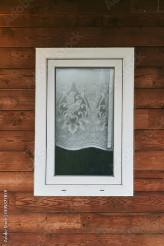 Plastic window in a wooden house. Close-up