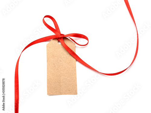 Beautiful red ribbon and blank tag on white background