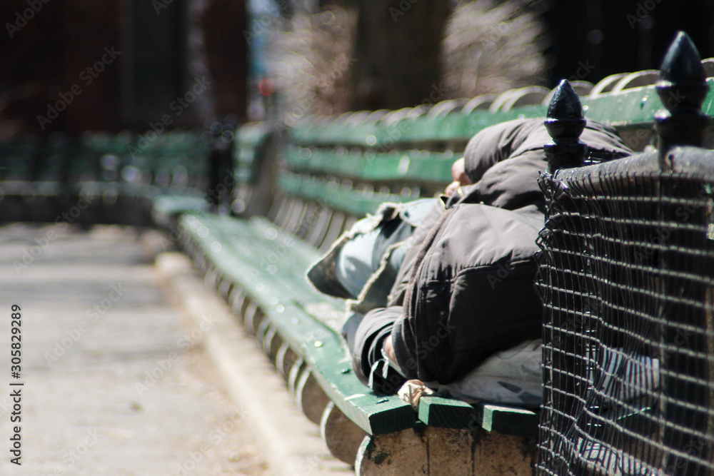 A man sleeping on a bench in New York City