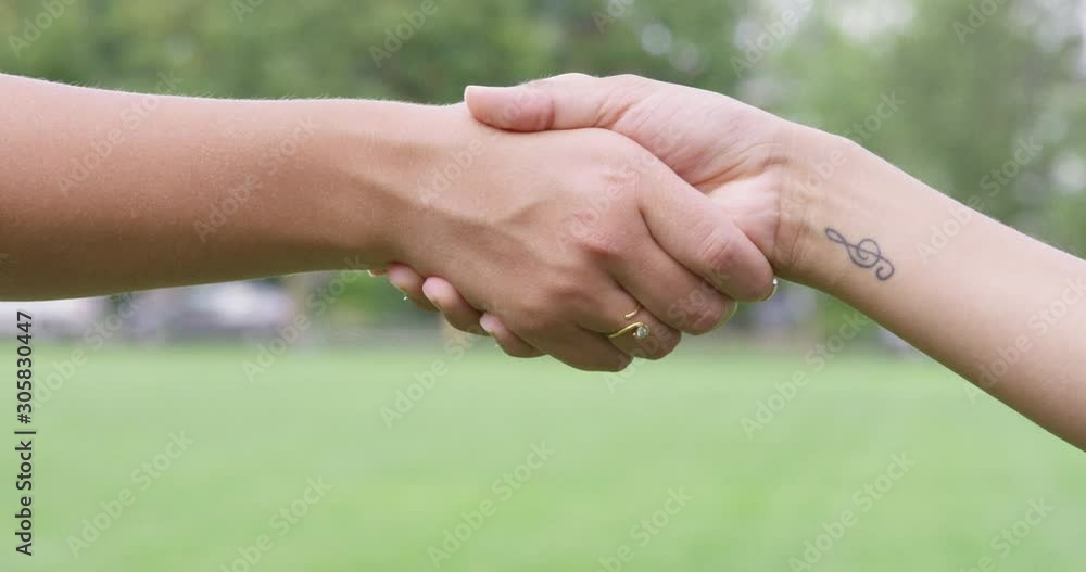 Close Up - Two women shake hands - shot on RED Close Up - Two women shake hands - shot on RED