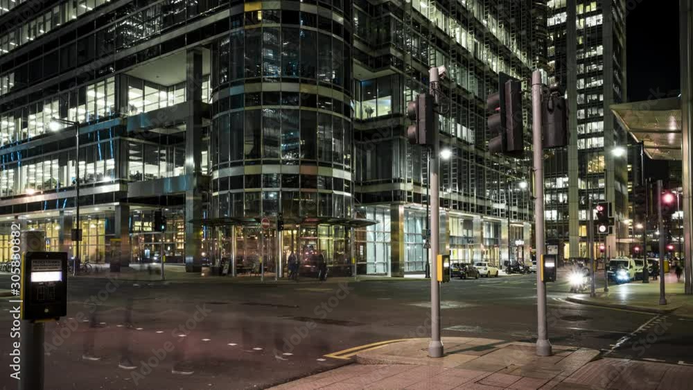 Busy city street at night time lapse with large office buildings Busy city street at night time lapse with large office buildings