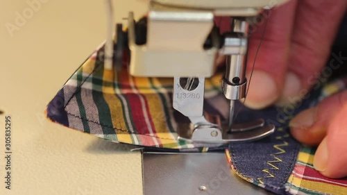 Close up of a tailor using a using an industrial  sewing machine to make a shirt photo