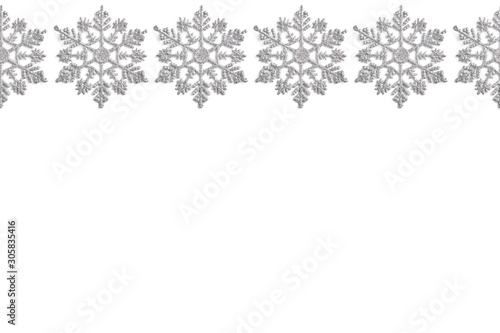 frame of Christmas decor in the form of silver snowflakes on a white background. new year layout, top view, flat lay