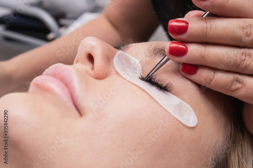 Artificial eyelash extensions from the master of eyelash extension in the beauty salon, medical tweezers hd. Artificial eyelash extensions from the master of
