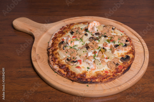 Tuna pizza with shrimp and pineapple, isolated, top view.