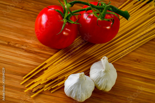 Ingredients used to make an Italian meal. Tomatos, bell peppers, garlic and spagetti 