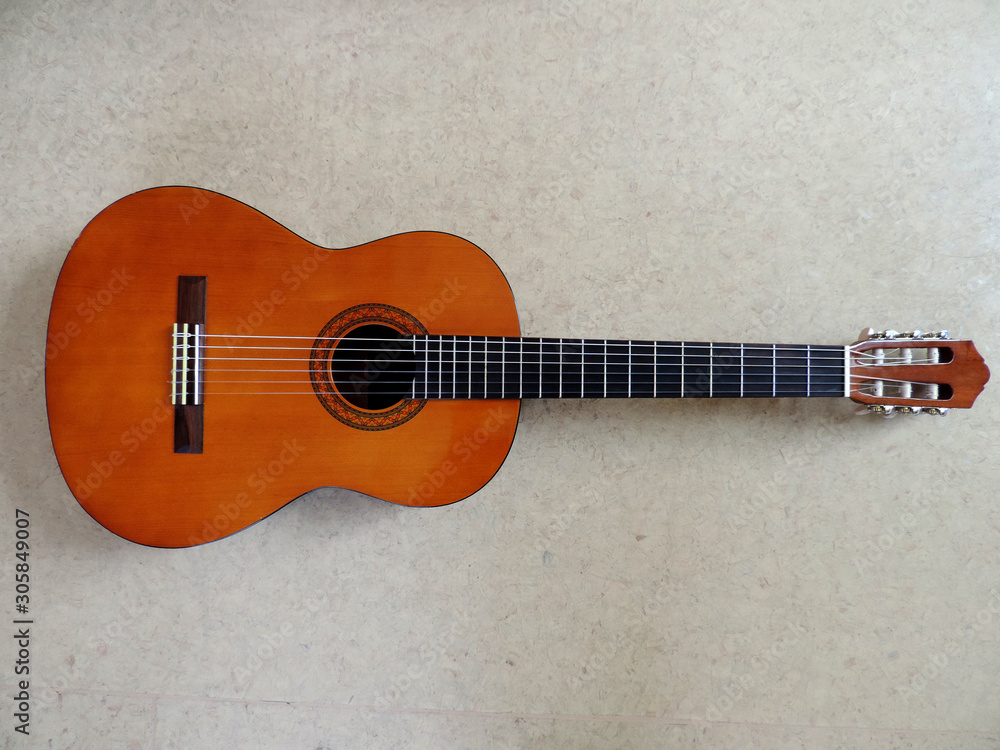 Fototapeta premium Classical six-string Acoustic Guitar on gray background. Selective focus.