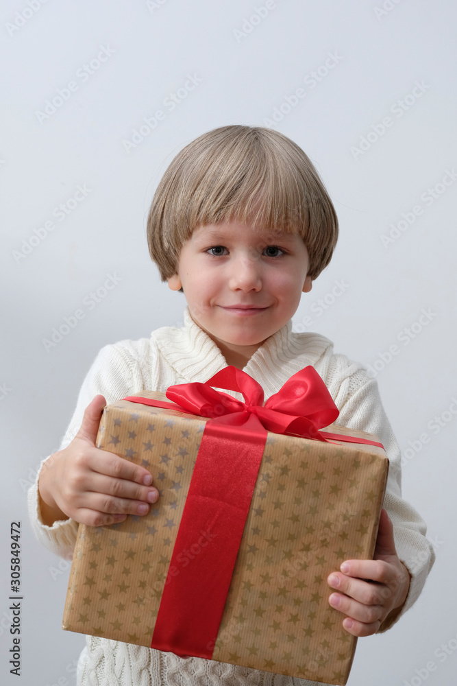 Child holding Christmas gift box in hand. Boy on white background. New year and x-mas concept. Child holding Christmas gift box in hand. Boy on white background. New year and x-mas concept.