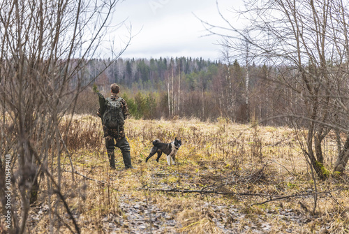 man in camouflage, man, hunter, stands and looks in the field, near a dog, autumn © Павел Прохацкий