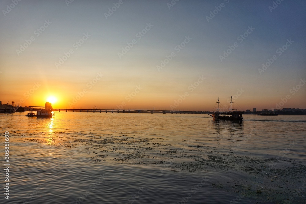 Two ships sail towards each other. Sunset on the Dnieper River.