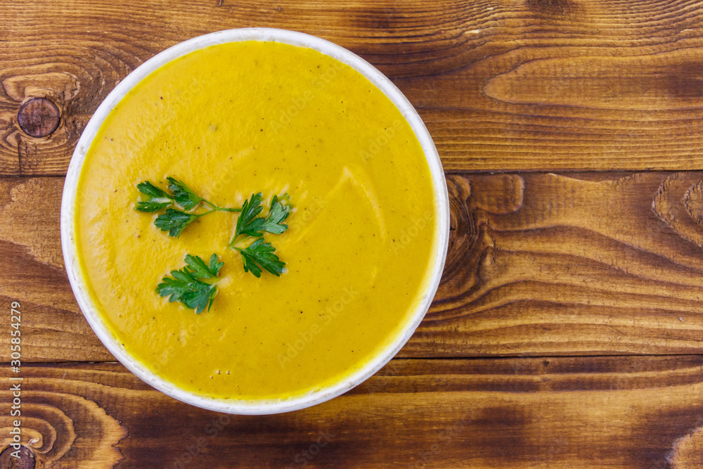 Pumpkin soup on a wooden table. Top view Pumpkin soup on a wooden table. Top view