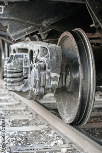 Wheel of a freight car standing on rails. Fixing the axle spring and shock absorber springs. Selective focus on the edge of the wheel.