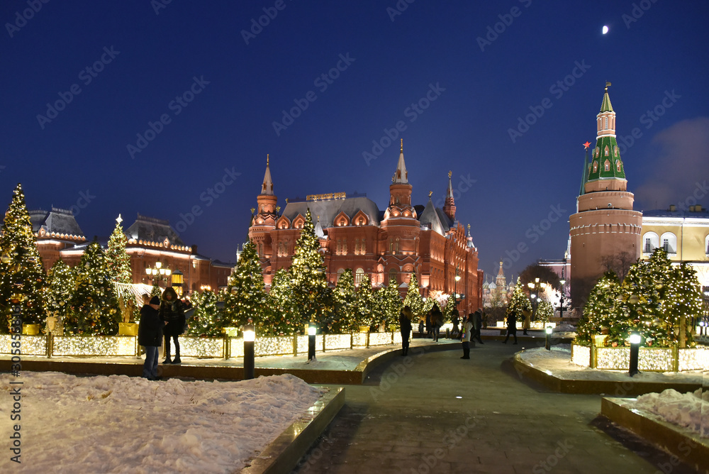 Decorated Christmas trees on the street against the background of the Historical Museum and Red Square