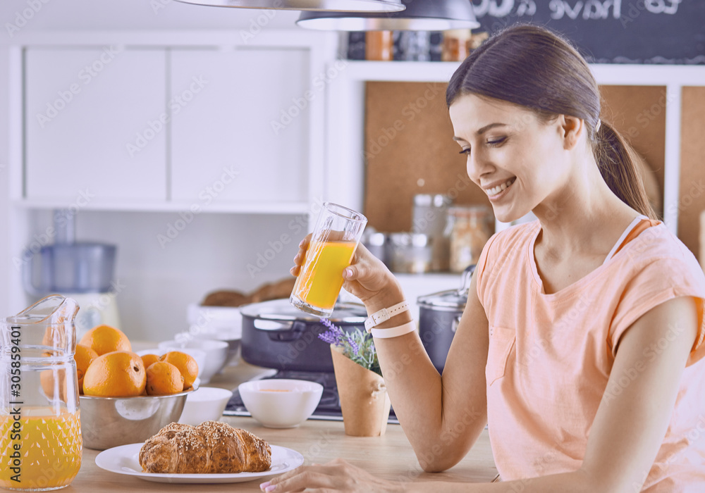Smiling pretty woman looking at mobile phone and holding glass Smiling pretty woman looking at mobile phone and holding glass
