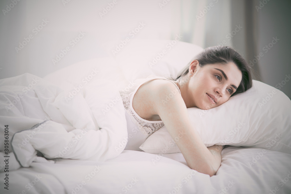 beautiful young woman basking in bed in the morning. Beautiful beautiful young woman basking in bed in the morning. Beautiful