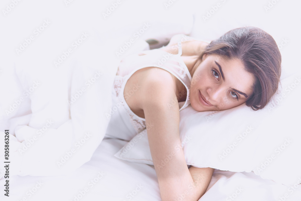 beautiful young woman basking in bed in the morning. Beautiful beautiful young woman basking in bed in the morning. Beautiful