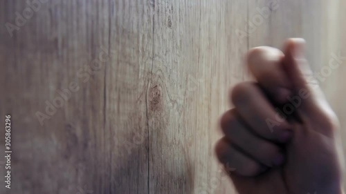 Close-up of hand knocking on door