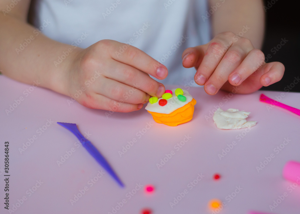 Child hands playing with colorful clay. Homemade plastiline. Girl molding modeling clay. Homemade clay. Child playing and creating from play dough.