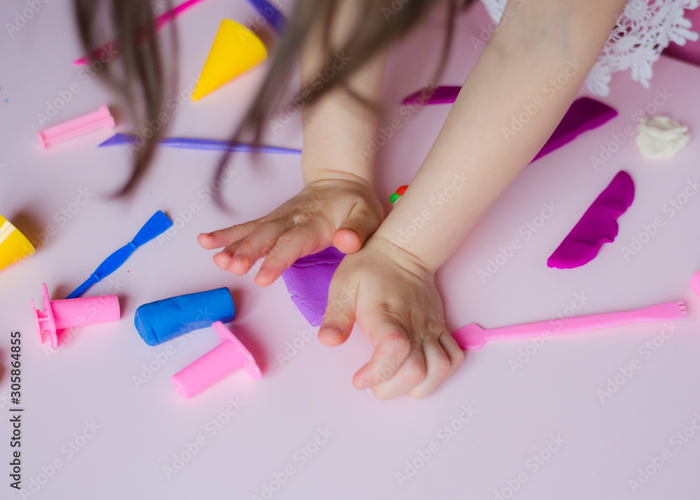 Child hands playing with colorful clay. Homemade plastiline. Girl molding modeling clay. Homemade clay. Child playing and creating from play dough. Child hands playing with colorful clay. Homemade plastiline. Girl molding modeling clay. Homemade clay. Child playing and creating from play dough.