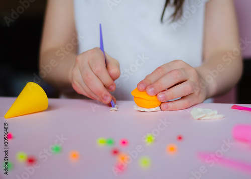 Child hands playing with colorful clay. Homemade plastiline. Girl molding modeling clay. Homemade clay. Child playing and creating from play dough.