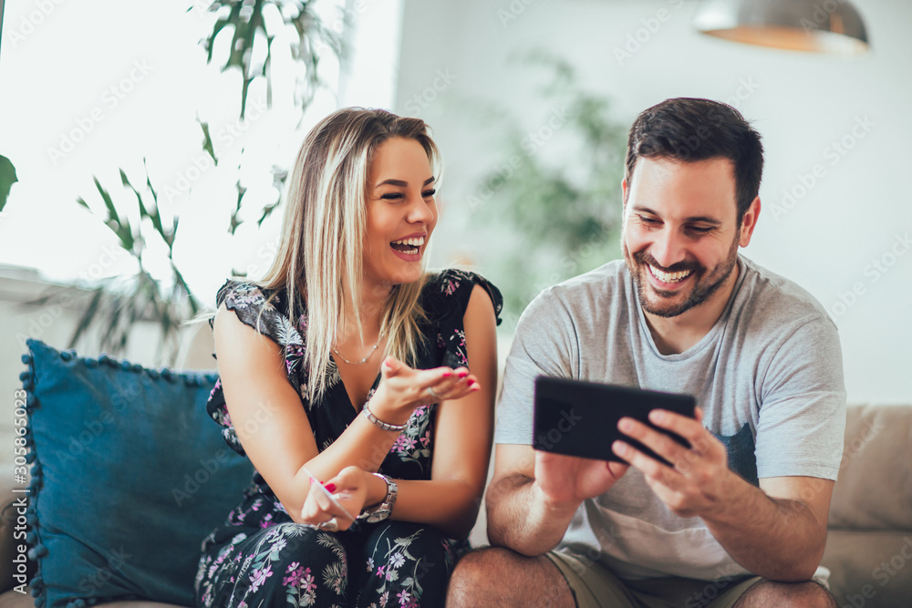 Smiling happy couple with tablet pc computer and credit or bank card shopping online at home Smiling happy couple with tablet pc computer and credit or bank card shopping online at home