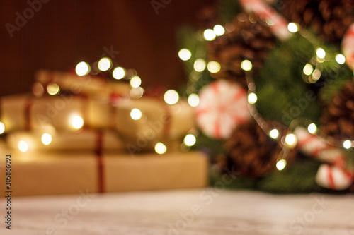 Gift boxes and Christmas wreath with a luminous garland. Blurred background without focus with bokeh