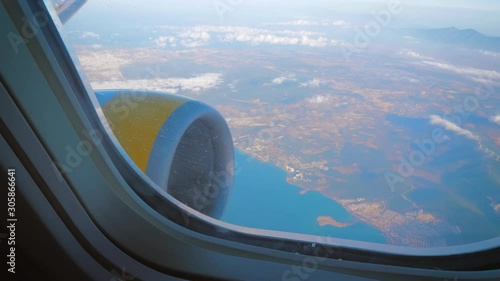 Airplane wing with a powerful turbojet engine above the clouds after takeoff. Highly effective lifting force.