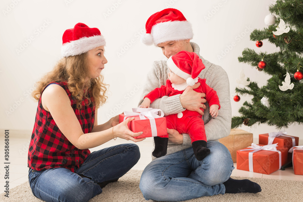 Happy couple with baby celebrating Christmas together at home. Happy couple with baby celebrating Christmas together at home.