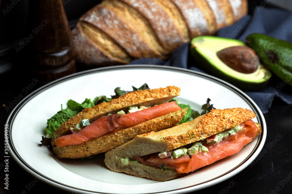 smoked salmon sandwich with avocado in sauce served in bread with sesame