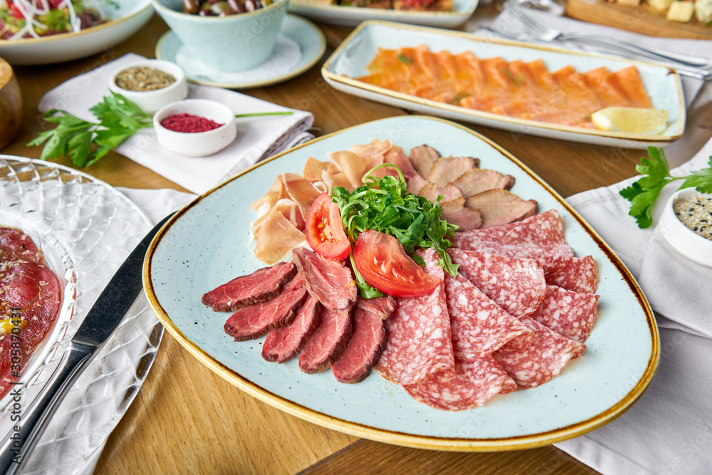 Meat plate, delicacy and Anantipasto. Salami, roast beef, Parma ham, smoked duck breast. Various snacks and antipasti on the table. Italian cuisine Restaurant menu, natural and organic food concept. Meat plate, delicacy and Anantipasto. Salami, roast beef, Parma ham, smoked duck breast. Various snacks and antipasti on the table. Italian cuisine Restaurant menu, natural and organic food concept.