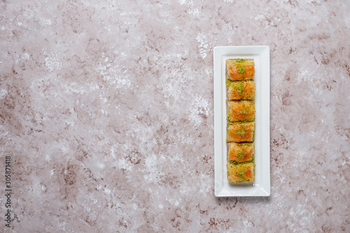 Traditional Turkish Pastry Dessert Baklava with pistachio nuts on concrete background.