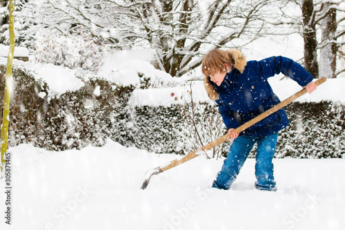 Child shoveling winter snow. Kids clear driveway.