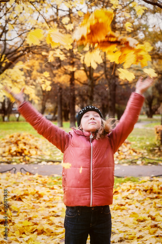Girl throws autumn leaves in the Park