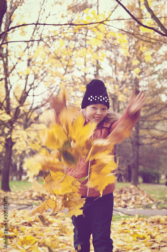 Girl throws autumn leaves in the Park