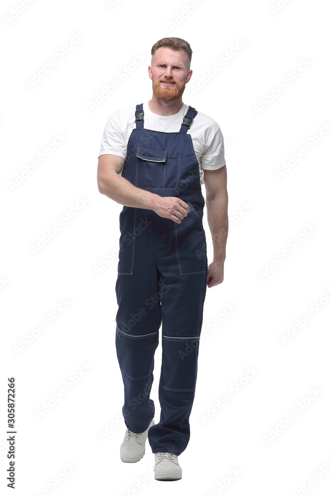 in full growth. confident man in overalls goes forward. in full growth. confident man in overalls goes forward.