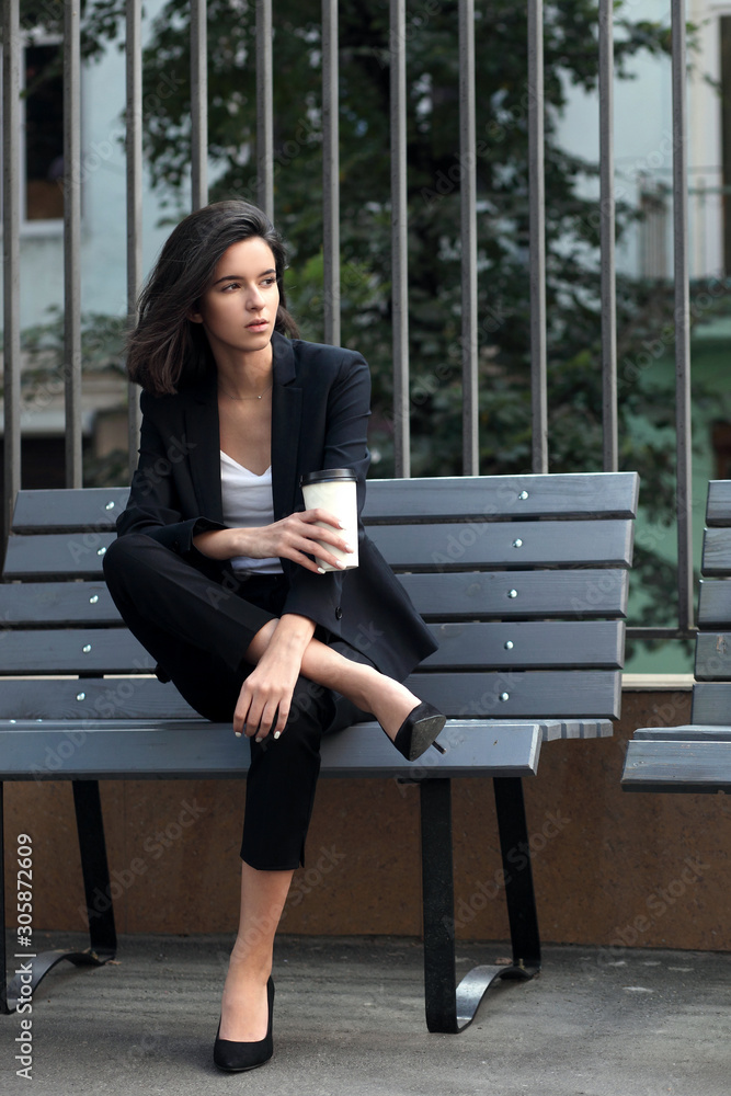 Young woman in the street drinking morning coffee and use her digital tablet. Young woman in the street drinking morning coffee and use her digital tablet.