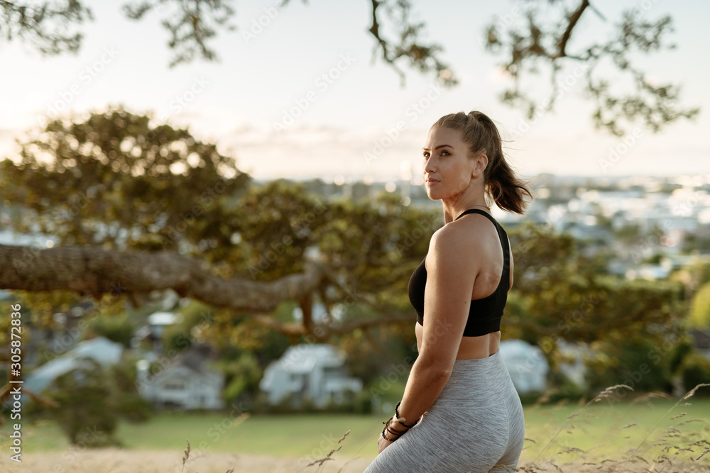 Young woman under tree in workout clothes Young woman under tree in workout clothes