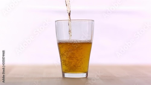 Wallpaper Mural Hand Pouring Juice From Clear Glass Bottle Into A Glass On A Countertop Torontodigital.ca