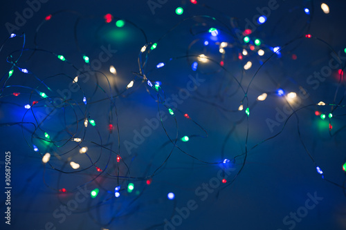 Christmas lights on dark blue background with copy space. Decorative garland