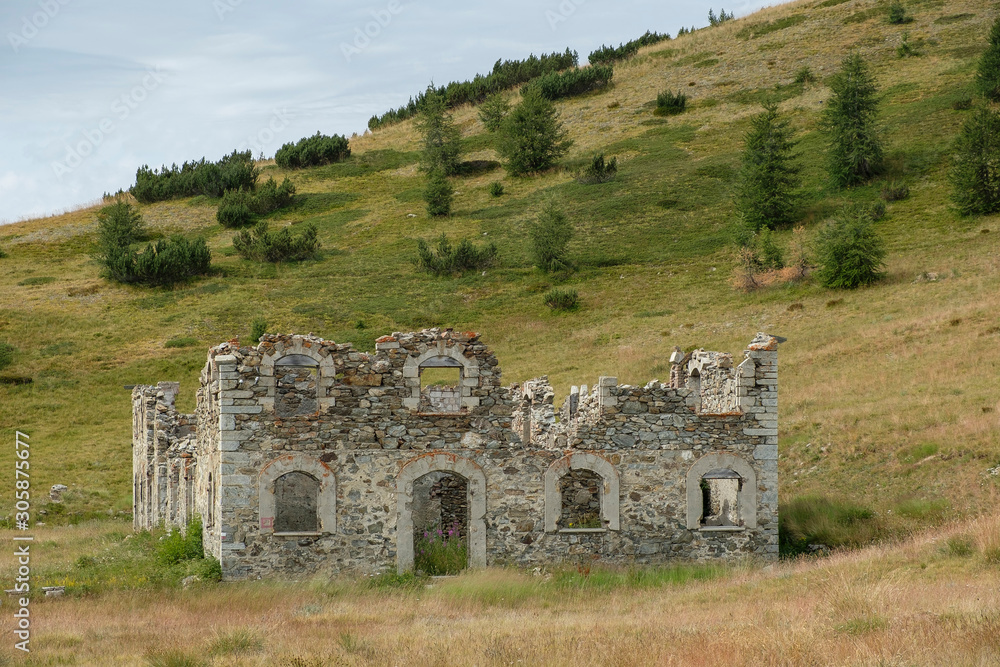 Ruin of a single army barracks in the middle of lonely mountain landscape in the Italian Alps