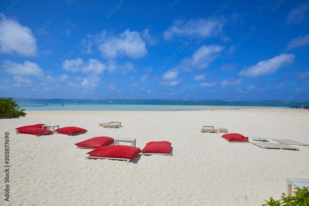 red sunbeds and white sand on the beach of the island of Mauritius red sunbeds and white sand on the beach of the island of Mauritius