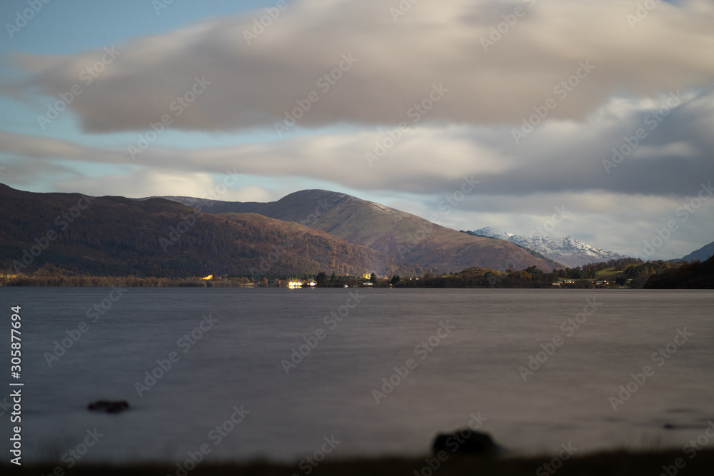 The clouds slowly moving away to show the bright stars shining over Loch Lomond Scotland The clouds slowly moving away to show the bright stars shining over Loch Lomond Scotland