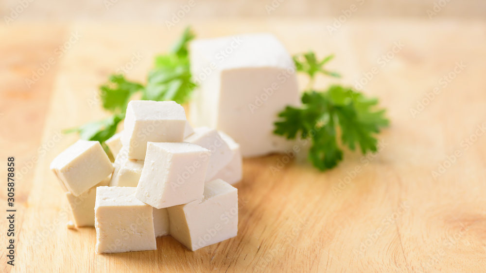 Sliced tofu on wooden background, vegetarian food Sliced tofu on wooden background, vegetarian food