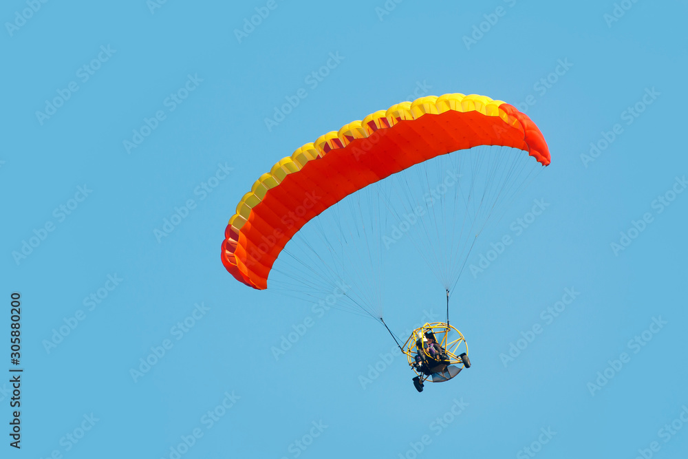 A paraglider with a motor on a sky background A paraglider with a motor on a sky background