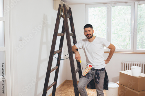 man renovating apartment, painting walls